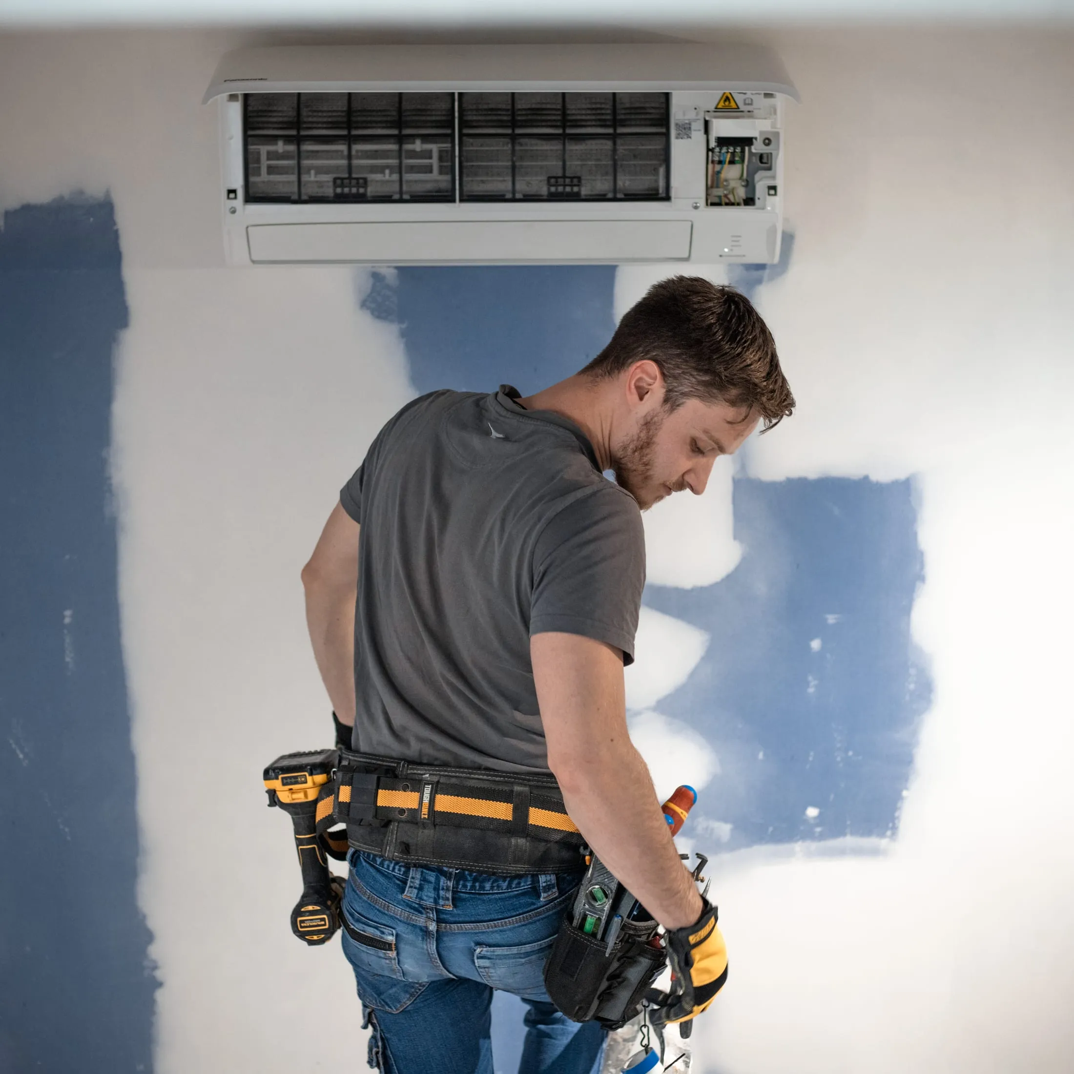 L'artisan Modern House Concept avec sa ceinture à outils sur un chantier