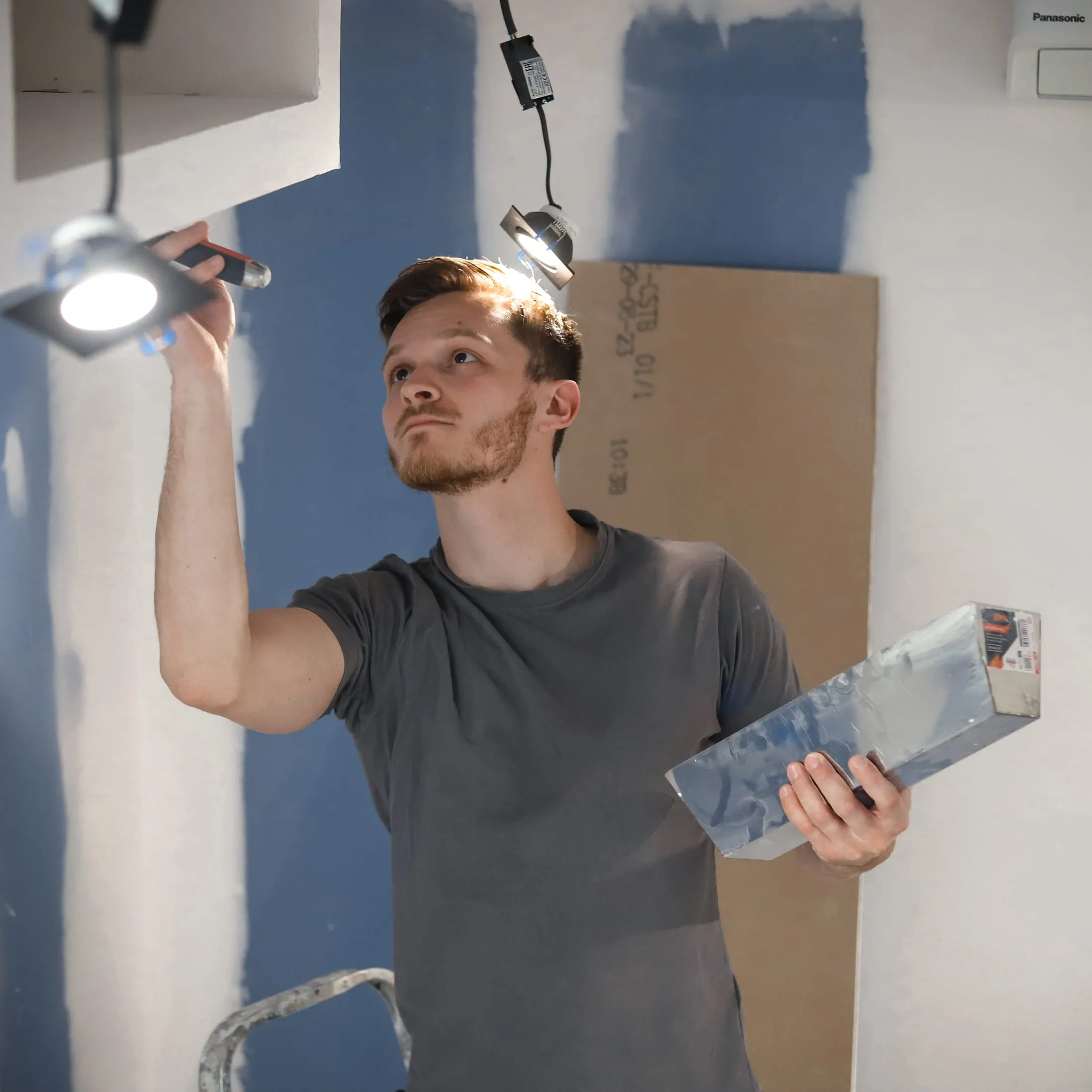 L'artisan Modern House Concept installant des spots au plafond